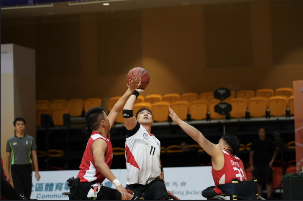 輪椅籃球運動員越過防守者投籃