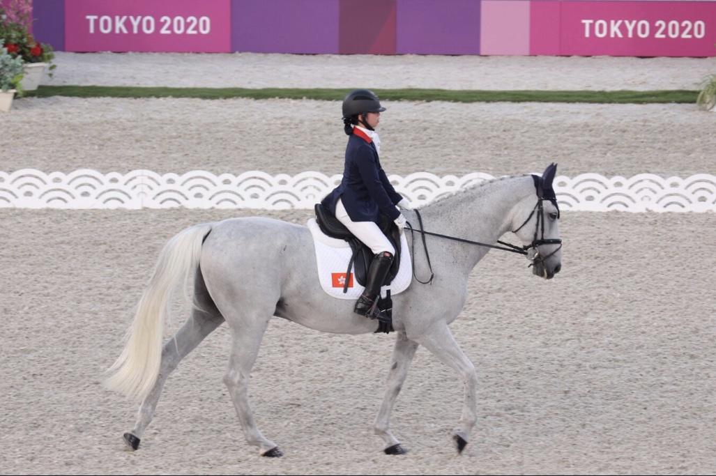 一名騎手正在東京2020殘奧會馬術比賽中騎著白色馬匹進行盛裝舞步表演