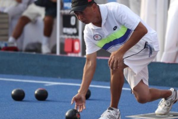 男子草地滾球選手蹲下準備投球動作