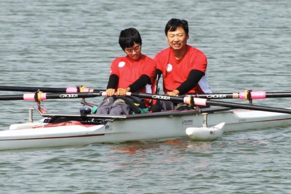 兩名穿著紅色運動服的選手正在進行賽艇比賽